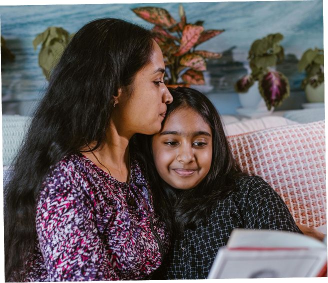 A mother and her daughter reading a book together